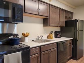 Great Mills apartment for rent - a kitchen with stainless steel appliances and dark wood cabinets