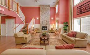 Upper Marlboro apartment for rent - A living room with a stone fireplace and a staircase.