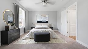 Lexington Park apartment for rent - A bedroom with a large bed, a dresser, and a mirror.