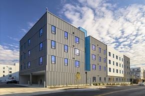 Baltimore apartment for rent - A modern building with a grey facade and blue accent windows.