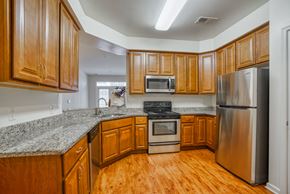 Laurel apartment for rent - a kitchen with wooden cabinets and granite counter tops and stainless steel appliances