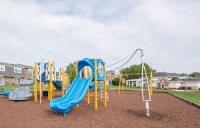 Edgewood townhouse for rent - A playground with a blue slide and yellow poles.
