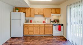 Edgewood townhouse for rent - A kitchen with wooden cabinets and a white refrigerator.
