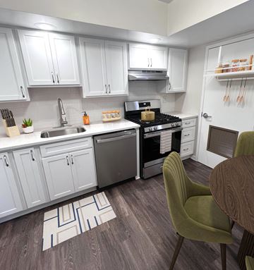 Baltimore apartment for rent - A kitchen with white cabinets and a green chair.