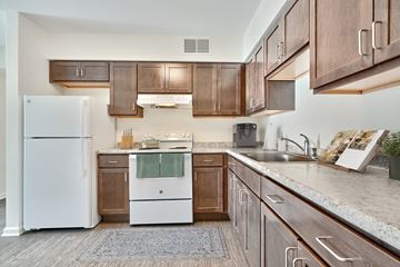 Berlin apartment for rent - A kitchen with a white refrigerator and wooden cabinets.