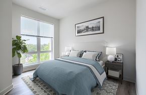 Silver Spring apartment for rent - A bedroom with a large bed and a window overlooking a green area.