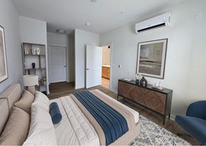 Baltimore apartment for rent - A bedroom with a bed, a couch, a chair, and a painting on the wall.