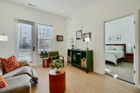 Baltimore apartment for rent - Now leasing senior 1-bedrooms in Baltimore, MD. A living room with a grey couch and a red pillow.