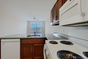 Baltimore apartment for rent - A kitchen with a white stove top oven and a white dishwasher.