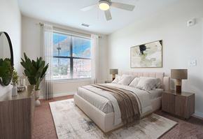 Baltimore apartment for rent - A bedroom with a large bed, a ceiling fan, and a window with a view of the outdoors.