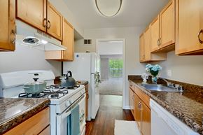 Silver Spring apartment for rent - A kitchen with a white stove top oven and wooden cabinets.