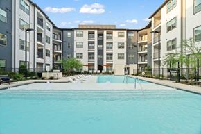 Houston apartment for rent - Apartment community pool featuring resort-style amenities, contemporary residential architecture, private balconies, and landscaped outdoor gathering spaces.