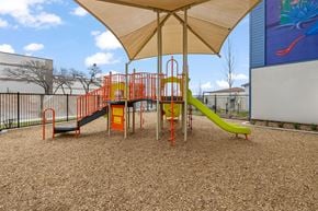 San Antonio apartment for rent - A playground with a yellow slide and orange and green play structures.