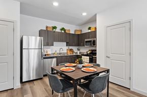 Converse apartment for rent - Modern apartment kitchen at The Esther with stainless steel appliances and dark wood cabinetry.