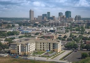 Fort Worth apartment for rent - A cityscape with a large building in the foreground and several skyscrapers in the background.