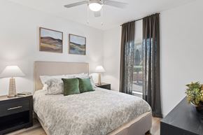 Converse apartment for rent - Bedroom at The Esther apartments with bed, dresser and nightstands in an open floor plan layout.