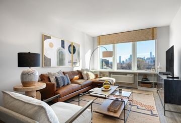 Jersey City apartment for rent - A living room with a brown leather couch and a wooden coffee table.