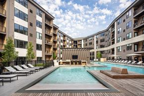Jersey City apartment for rent - A large outdoor pool surrounded by lounge chairs and apartment buildings.