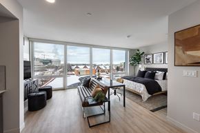 Cleveland apartment for rent - A modern bedroom with a large bed and a view of the city.