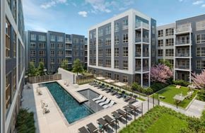 Hyattsville apartment for rent - A modern apartment complex with a pool and outdoor seating area.