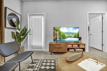 San Antonio apartment for rent - A living room with a television displaying a scenic view of a lake and mountains.