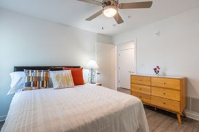 Evansville apartment for rent - Light-filled bedroom with a cozy bed, soft accent pillows, and dresser storage, designed for everyday comfort and relaxation.