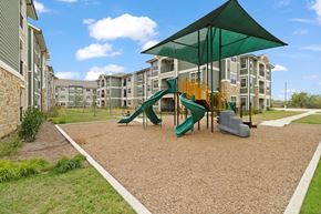 Manor apartment for rent - A playground with a green slide and a yellow slide.