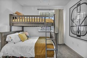 Austin apartment for rent - A bedroom with a white bed and a yellow throw blanket.