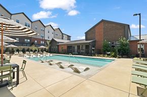Mesquite apartment for rent - Resort-style swimming pool featuring in-water lounge seating, sun deck areas, and outdoor gathering space for residents.
