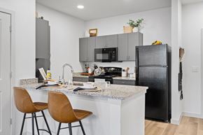 San Antonio apartment for rent - a kitchen with black appliances and a counter with bar stools