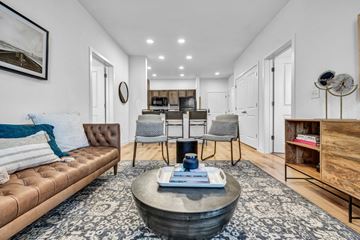 Manor apartment for rent - A living room with a brown leather sofa and a coffee table in the center.