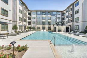 Austin apartment for rent - an outdoor swimming pool with an apartment building in the background