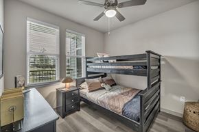 Von Ormy apartment for rent - A bedroom with a bunk bed and a ceiling fan.