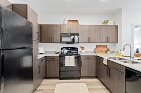 San Antonio apartment for rent - a modern kitchen with black appliances and wooden cabinets