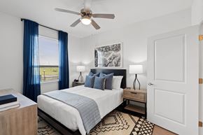 San Marcos apartment for rent - Bright bedroom featuring a ceiling fan and contemporary design elements.