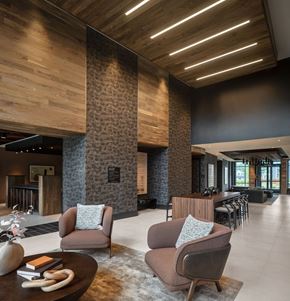 Woodbridge apartment for rent - A modern living room with a wooden ceiling and a stone pillar.