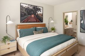Sanford apartment for rent - A bedroom with a large bed and a painting of a bridge on the wall.