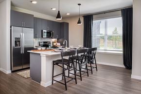 Dallas apartment for rent - a kitchen with a island with bar stools and a stainless steel refrigerator