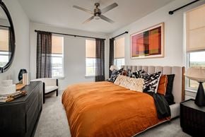 Austin townhouse for rent - A bedroom with a bed in the center and a painting on the wall above it.