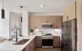 Kissimmee apartment for rent - A modern kitchen with wooden cabinets and stainless steel appliances.