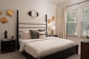 Kissimmee apartment for rent - A bedroom with a large bed and a window with blinds.