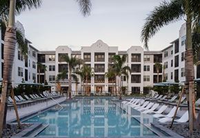 Kissimmee apartment for rent - A large white hotel with a pool in front.