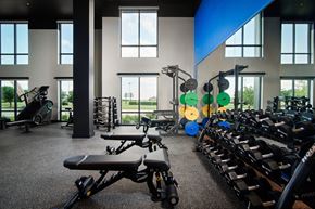 Carrollton apartment for rent - A gym with a variety of equipment including weights and a rowing machine.