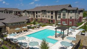 Kyle apartment for rent - A large building with a pool in front of it.