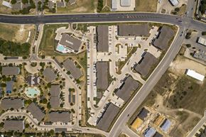 Converse apartment for rent - Overhead view of a large apartment property with rows of buildings, structured parking lots, and shared outdoor spaces connected by sidewalks
