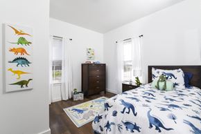 Columbus apartment for rent - a bedroom with a bed with blue and white sheets and dinosaur bedding