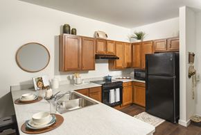 Columbus apartment for rent - a kitchen with black appliances and wooden cabinets and a white counter top
