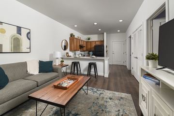 Columbus apartment for rent - A modern living room with a grey couch, a wooden coffee table, and a painting on the wall.