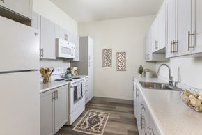 Irvington apartment for rent - A kitchen with white cabinets and a rug on the floor.