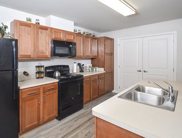 Tiffin apartment for rent - A kitchen with wooden cabinets and black appliances.
